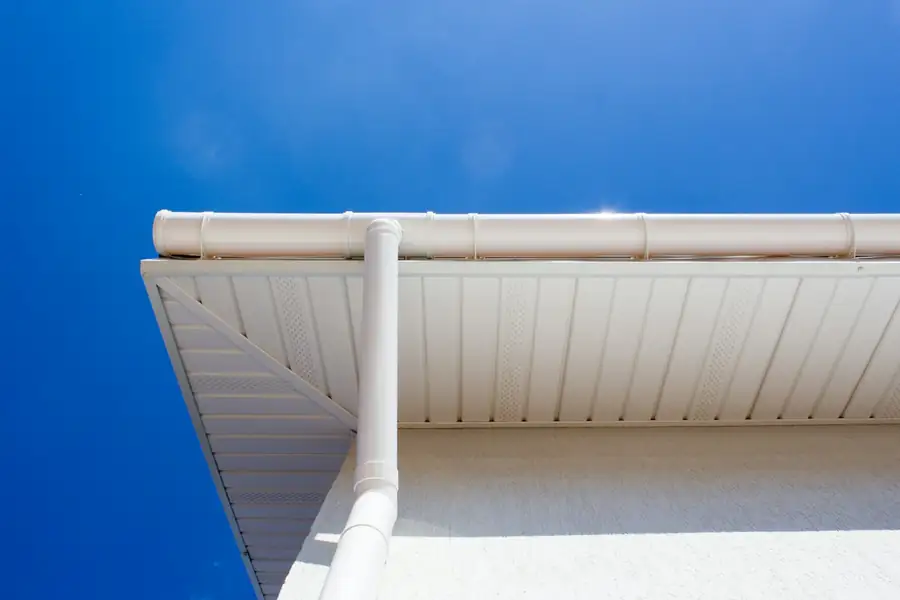 New seamless gutter run along a roofline against a blue sky